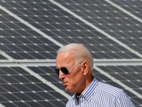 Now-U.S. president Joe Biden walks past solar panels while touring the Plymouth Area Renewable Energy Initiative in Plymouth, New Hampshire in June, 2019.