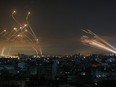 The Israeli Iron Dome missile defence system (left) intercepts rockets (right) fired by the Hamas movement towards southern Israel from Beit Lahia in the northern Gaza Strip as seen in the sky on May 14, 2021.