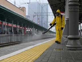 A serviceman of the Russian Ministry for Civil Defence, Emergencies and Elimination of Consequences of Natural Disasters, wearing protective gear, disinfects Moscow's Belorussky railway station on June 11, 2021, amid the COVID-19 pandemic.