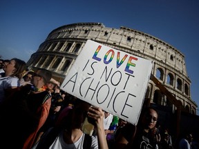 In this file photo taken on June 8, 2019, participants walk past the Colosseum monument in the Italian capital, Rome, during the annual Gay Pride parade.