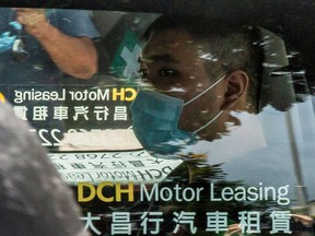 This file photo taken on July 6, 2020 shows Tong Ying-kit, who is accused of deliberately driving his motorcycle into a group of police officers on July 1, 2020, arriving at the West Kowloon Court in Hong Kong.