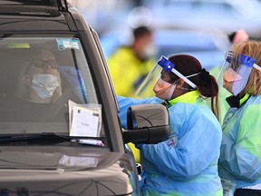 Health workers conduct COVID-19 tests at the St. Vincents Hospital drive-through testing clinic at Bondi Beach in Sydney June 27, 2021, on the first full day of a two-week coronavirus lockdown to contain an outbreak of the highly contagious Delta variant.