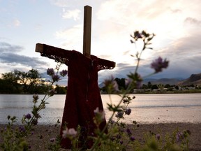 A child's red dress hangs on a stake near the grounds of the former Kamloops Indian Residential School after the remains of 215 children, some as young as three years old, were found at the site in Kamloops, British Columbia, June 5, 2021.