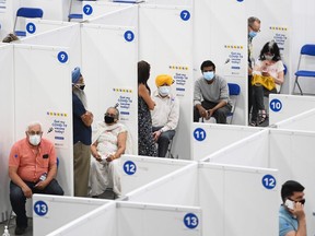 People receive their COVID-19 vaccine at the 'hockey hub' mass vaccination facility at the CAA Centre during the COVID-19 pandemic in Brampton, Ont., on Friday, June 4, 2021.