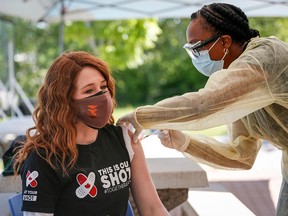 Olympic medallist Clara Hughes receives a second dose of a COVID-19 vaccine at a community vaccination clinic at the Stoney Nakoda First Nation health services centre in Morley, Alta., on June 17, 2021. Although there are minor structural differences between Pfizer and Moderna vaccines, "their effects on the immune system are identical for all intents and purposes," writes infectious diseases expert Dr. Zain Chagla.