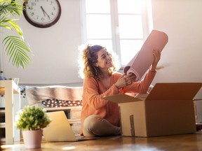 Woman unpacking box with workout equipment at home
