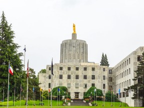 The Oregon Capitol Building in Salem Oregon shows the pioneer statue atop the capitol.