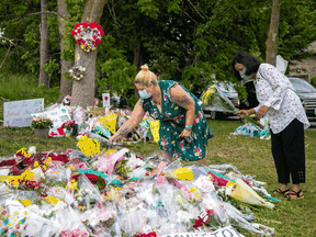 People visit a makeshift memorial at the scene where a man driving a pickup truck ran over a Muslim family in what police say was a deliberately targeted anti-Muslim hate crime, in London, Ontario, June 9, 2021.
