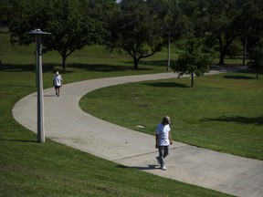 People walk through Buffalo Bayou Park during a heatwave in Houston, Texas, U.S., on Thursday, June 17