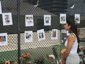 A woman looks at pictures of people missing from the condominium building.
