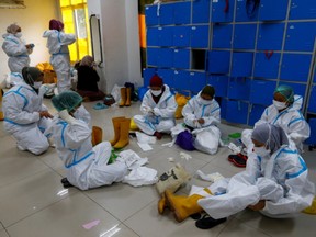 Healthcare workers put on personal protective equipment (PPE) as they prepare to treat patients at the emergency hospital for the coronavirus disease (COVID-19) in Jakarta, Indonesia, June 17, 2021.