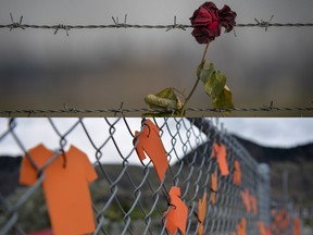 Top: A memorial rose is left on the electric fence of the Auschwitz extermination camp. Bottom: Orange shirts line the fence outside of the Sk'elep School of Excellence near the grounds of the former Kamloops Indian Residential School.
