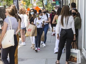 Retail store line ups along Queen St. W. (East of Spadina Ave.) as a part of Ontario's Step 1 reopening in Toronto, Ont. on Friday June 11, 2021.