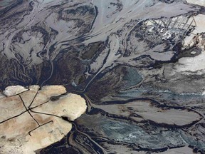 File photo: Oil goes into a tailings pond at the Suncor  oil sands operations near Fort McMurray, Alberta, 2014.