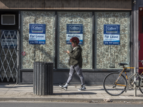 A pedestrian wearing a mask walks past a shuttered business now for lease on Toronto's Queen Street during the Covid 19 Pandemic, Wednesday March 24, 2021.