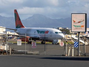 A Boeing 737 cargo aircraft with two crew on board was forced to make an emergency landing on the water off Honolulu early Friday after the pilots reported engine trouble, the Federal Aviation Administration said.