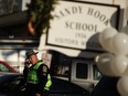 A police officer stands outside of the entrance to the Sandy Hook School on December 15, 2012 in Newtown, Connecticut. Twenty six people were shot dead, including twenty children, after a gunman opened fire at the school.