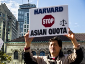 A demonstrator against Harvard University's admission process holds a sign that reads, "Harvard Stop Asian Quota," during a protest in Boston in 2018.