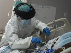 A member of the medical staff wearing full PPE brushes a patient's teeth in the COVID-19 intensive care unit at the United Memorial Medical Center on June 30, 2020 in Houston, Texas.