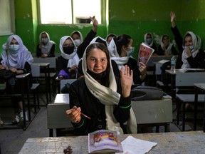 A 17-year-old girl raises her hand, while attending class at the Zarghoona high school in Kabul on July 25. There are widespread fears that the Taliban, which already control around half the country, will reintroduce its notorious system barring girls and women from almost all work, and access to education.