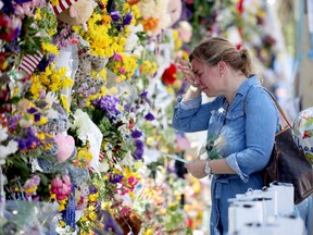 Laura Solla weeps as she places flowers near the memorial site for victims of the collapsed 12-story Champlain Towers South condo building on July 08 in Surfside, Florida.