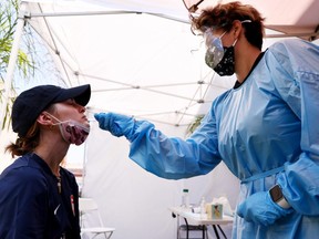 A medical assistant administers a COVID-19 test to a person at Sameday Testing on July 14, 2021 in Los Angeles, California.