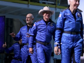 Blue Origin’s New Shepard crew (L-R) Oliver Daemen (hidden), Mark Bezos, Jeff Bezos, and Wally Funk arrive for a press conference after flying into space in the Blue Origin New Shepard rocket on July 20, 2021 in Van Horn, Texas.