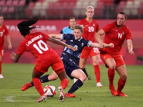 Ellen White (No. 9) of Team Great Britain shoots whilst under pressure from Ashley Lawrence (No. 10) and Vanessa Gilles (No. 14) of Team Canada during the Women's Group E match between Canada and Great Britain at the Tokyo 2020 Olympic Games at Kashima Stadium on July 27, 2021 in Kashima, Ibaraki, Japan.