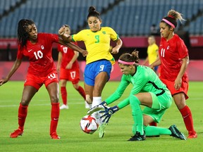 Stephanie Labbe #1 of Team Canada collects the ball whilst under pressure from Debinha #9 of Team Brazil during the Women's Quarter Final match between Canada and Brazil on day seven of the Tokyo 2020 Olympic Games at Miyagi Stadium on July 30, 2021 in Rifu, Miyagi, Japan.