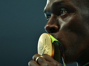 Gold medalist Usain Bolt of Jamaica kisses his gold medal on the podium during the medal ceremony for the Men's 100 metres on Day 10 of the Rio 2016 Olympic Games at the Olympic Stadium on August 15, 2016 in Rio de Janeiro, Brazil.