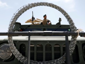 An Afghan security forces member keeps watch as he sits in an army vehicle in Bagram U.S. air base, after American troops vacated it, in Parwan province, Afghanistan July 5, 2021.