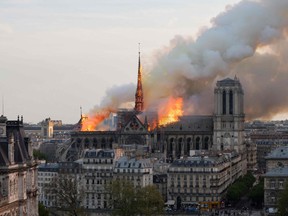 In this photo taken on April 15, 2019, smoke billows as flames burn through the roof of the Notre-Dame de Paris Cathedral in the French capital Paris.