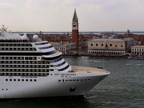 The MSC Orchestra cruise ship moves past the Bell Tower and the Doge's Palace in Venice's Piazza San Marco.