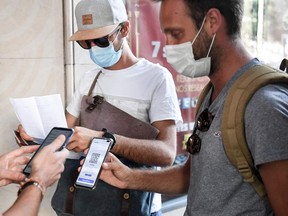 Spectators have their health passport checked before they enter Grand Rex cinema to watch the screening of Kaamelott, directed by French Alexandre Astier, in Paris, on July 21, 2021.