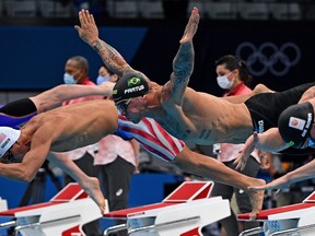 USA's Michael Andrew (L), Brazil's Bruno Fratus (C) and Netherlands' Thom de Boer (R) dive to start in a heat for the men's 50m freestyle swimming event during the Tokyo 2020 Olympic Games at the Tokyo Aquatics Centre in Tokyo on July 30, 2021. (Photo by Oli SCARFF / AFP) (Photo by OLI SCARFF/AFP via Getty Images)