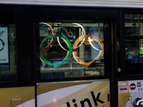The reflection of the Olympic Rings is seen on a bus window in Tokyo's Nihonbashi district on July 24, 2021.