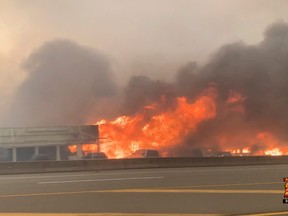 Flames rise from a burning building along a street during a wildfire in Lytton, on June 30 in this still image obtained from a social media video.