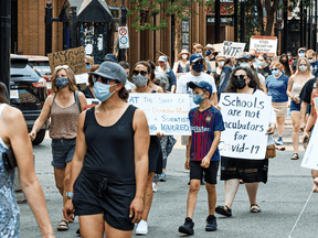 Protesters rally against the Alberta government's planned removal of COVID-19 restrictions, in downtown Calgary on Friday, July 30, 2021.