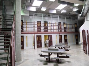 In this file photo made during an escorted visit and reviewed by the US military shows an US Army soldier walking at unused common detainee space in "Camp 6" detention facility at the US Naval Station in Guantanamo Bay, Cuba, April 8, 2014.