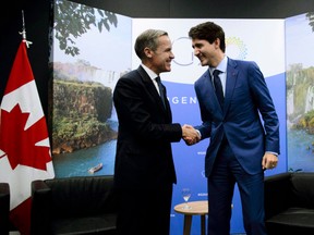 Mark Carney, left, shakes hands with Prime Minister Justin Trudeau at the G20 Summit in Buenos Aires, in 2018.