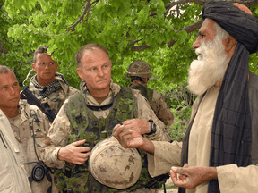 Then-Brigadier General David Fraser is escorted into a village during a visit to the Shah Wali Kot region of Afghanistan in 2006.