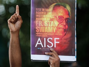 A man gestures as he holds a placard during a protest in Mumbai on July 7, 2021, to show solidarity with 84-year-old Catholic priest and activist Father Stanislaus Lourduswamy, commonly known as Stan Swamy, who died of COVID-19 after being imprisoned under an anti-terrorism law.