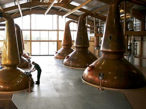 An employee checks a man-door on a copper pot still used to distil The Glenlivet single malt whisky, produced by Pernod Ricard SA, at the company's distillery in Ballindalloch, U.K., on Tuesday, Aug. 5, 2014. Scottish nationalist leader Alex Salmond and former Chancellor of the Exchequer Alistair Darling, who leads the 'No' campaign, clashed over the risks and merits of independence six weeks before the Sept. 18 referendum that could bring an end to the U.K.