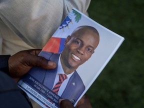 A person holds a photo of late Haitian President Jovenel Moise, who was shot dead earlier this month, during his funeral at his family home in Cap-Haitien, Haiti.