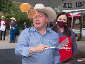Alberta Premier Jason Kenney shows off his pancake-flipping skills at the annual Premier’s Stampede Breakfast in downtown Calgary on July 12, 2021.