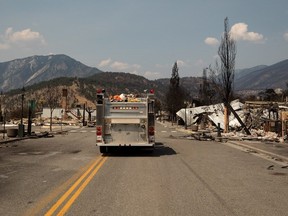 A fire truck travels down Main Street past damaged structures in Lytton, B.C., on July 9, 2021.