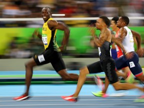 Usain Bolt of Jamaica looks at Andre De Grasse of Canada as they compete in the 2016 Rio Olympics, Men's 100m Semifinals at the Olympic Stadium in Rio de Janeiro, Brazil, August 14, 2016.