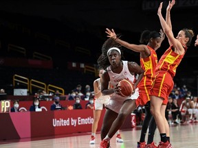 Canada's Laeticia Amihere (L) goes to the basket past Spain's Astou Ndour (2L) in the women's preliminary round group A basketball match between Spain and Canada during the Tokyo 2020 Olympic Games at the Saitama Super Arena in Saitama on August 1, 2021. (Photo by Aris MESSINIS / AFP)