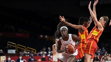 Canada's Laeticia Amihere (L) goes to the basket past Spain's Astou Ndour (2L) in the women's preliminary round group A basketball match between Spain and Canada during the Tokyo 2020 Olympic Games at the Saitama Super Arena in Saitama on August 1, 2021. (Photo by Aris MESSINIS / AFP)
