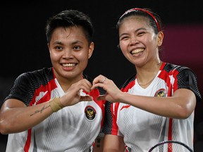Indonesia's Apriyani Rahayu (L) poses with Indonesia's Greysia Polii after winning their women's doubles badminton group stage match against Japan's Sayaka Hirota and Japan's Yuki Fukushima,